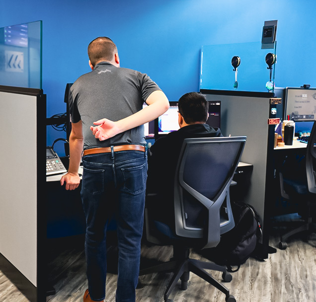 Manager looking over the shoulder of a technician